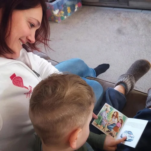 Pflegekraft liest einem Kind ein Buch vor